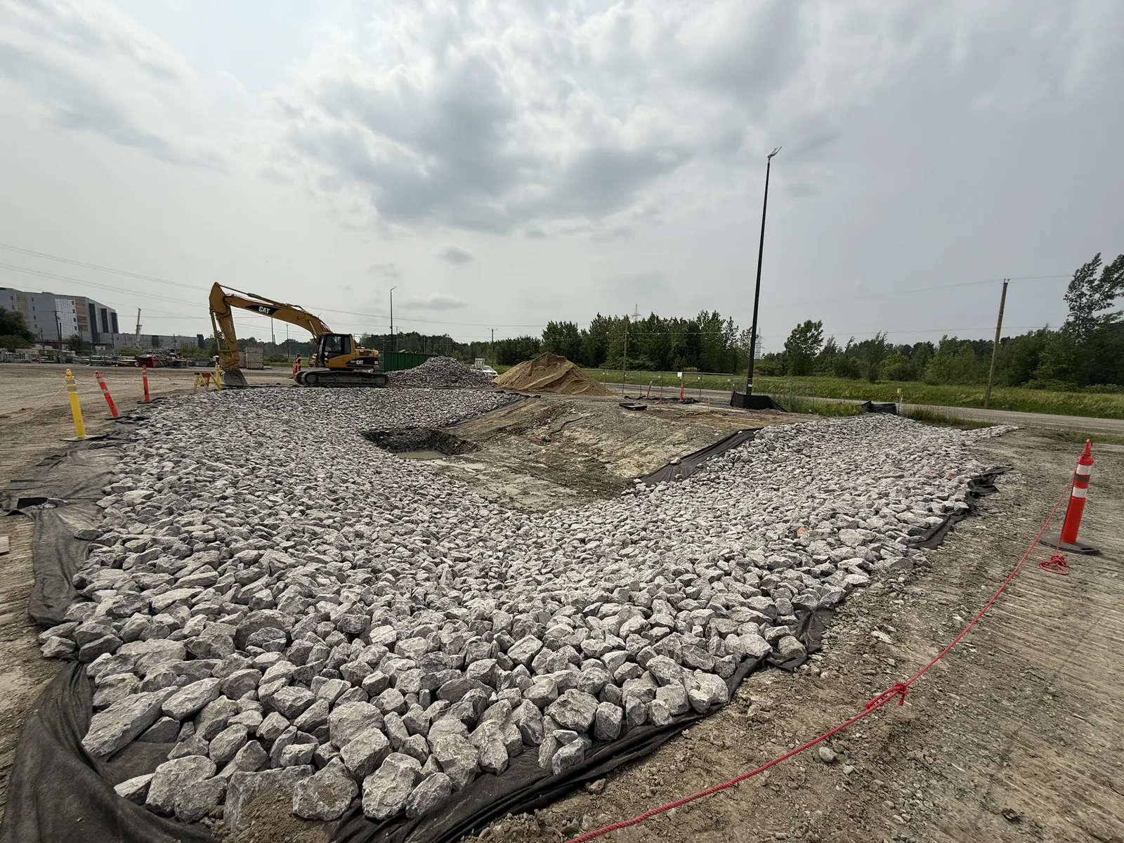 Enrochement — Pelle Caterpillar et enrochement de pierre sur un chantier.