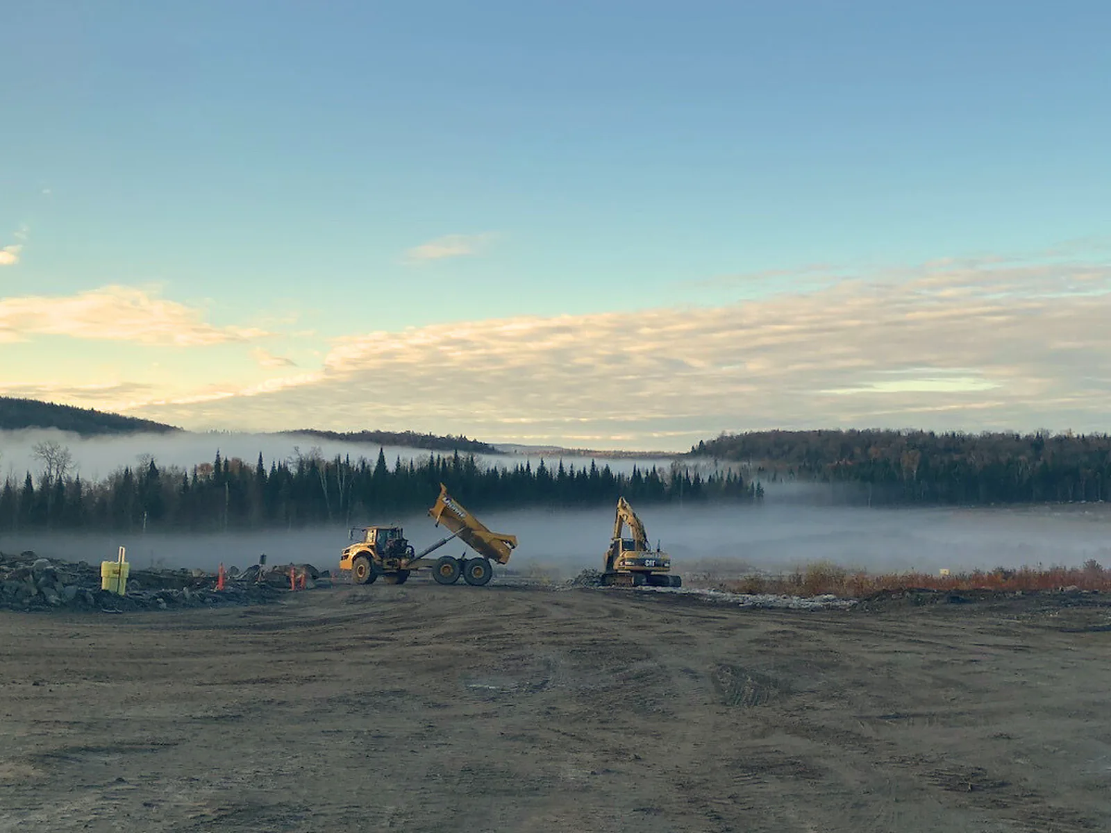 Chantier au lever du jour — Machinerie lourde sur un chantier dans la brume matinale.