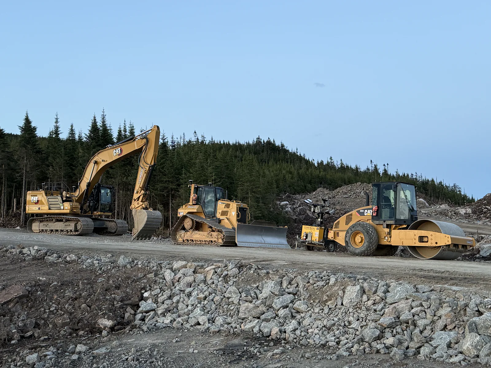 Pelle, bouteur et compacteur — Pelle, bouteur et rouleau compacteur Caterpillar sur un chantier.