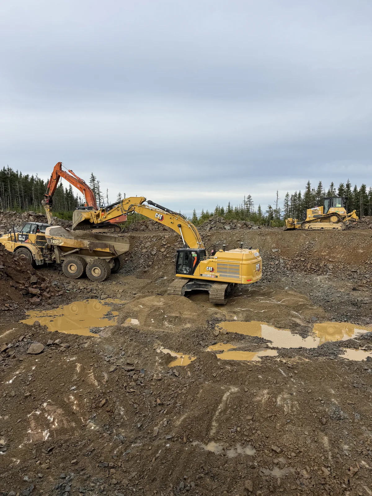 Excavation de roc et camion articulé — Pelle Caterpillar chargeant un camion articulé en excavation de roc.