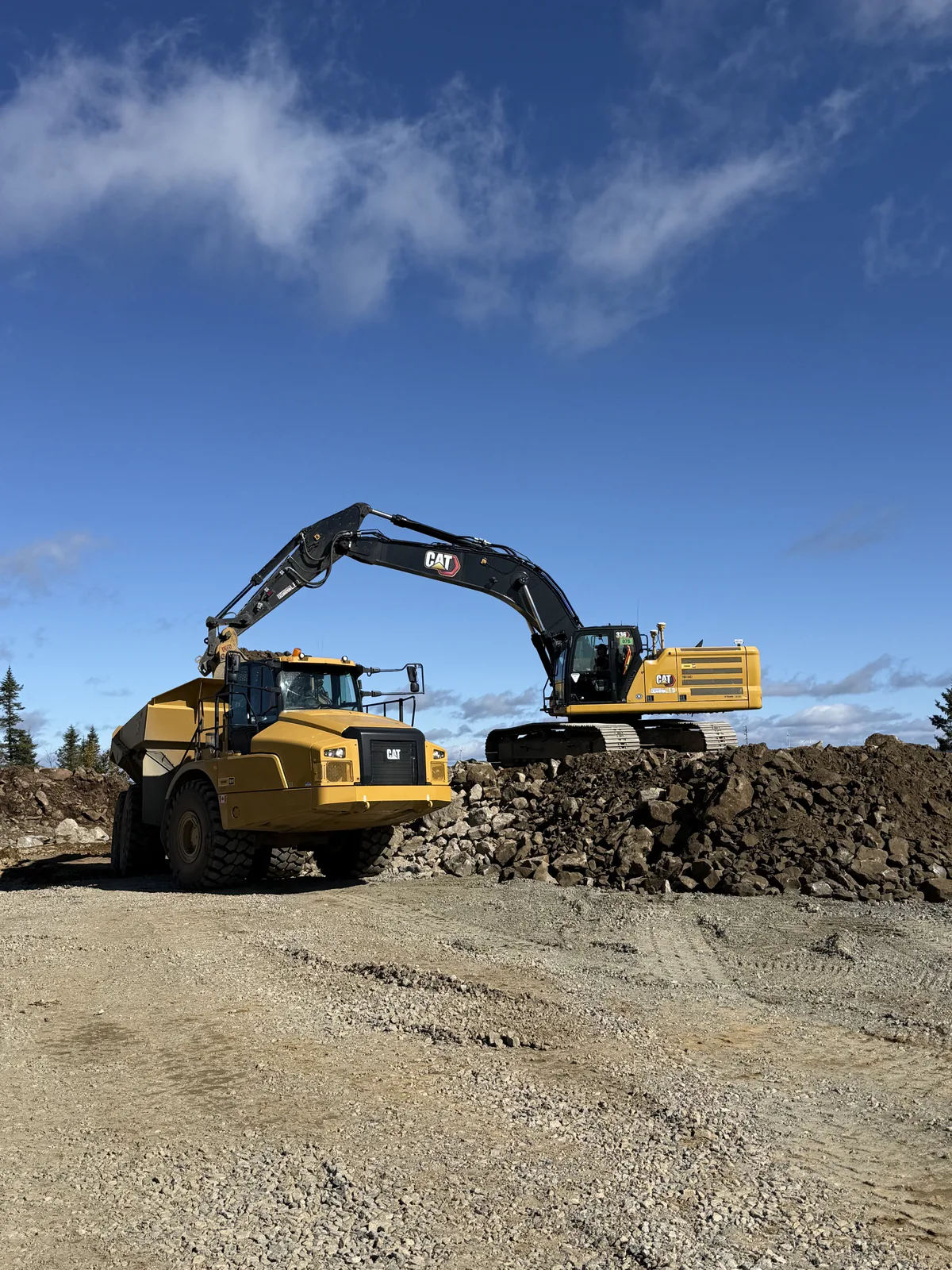 Plateforme granulaire — Pelle Caterpillar et camion tombereau sur une plateforme de gravier.