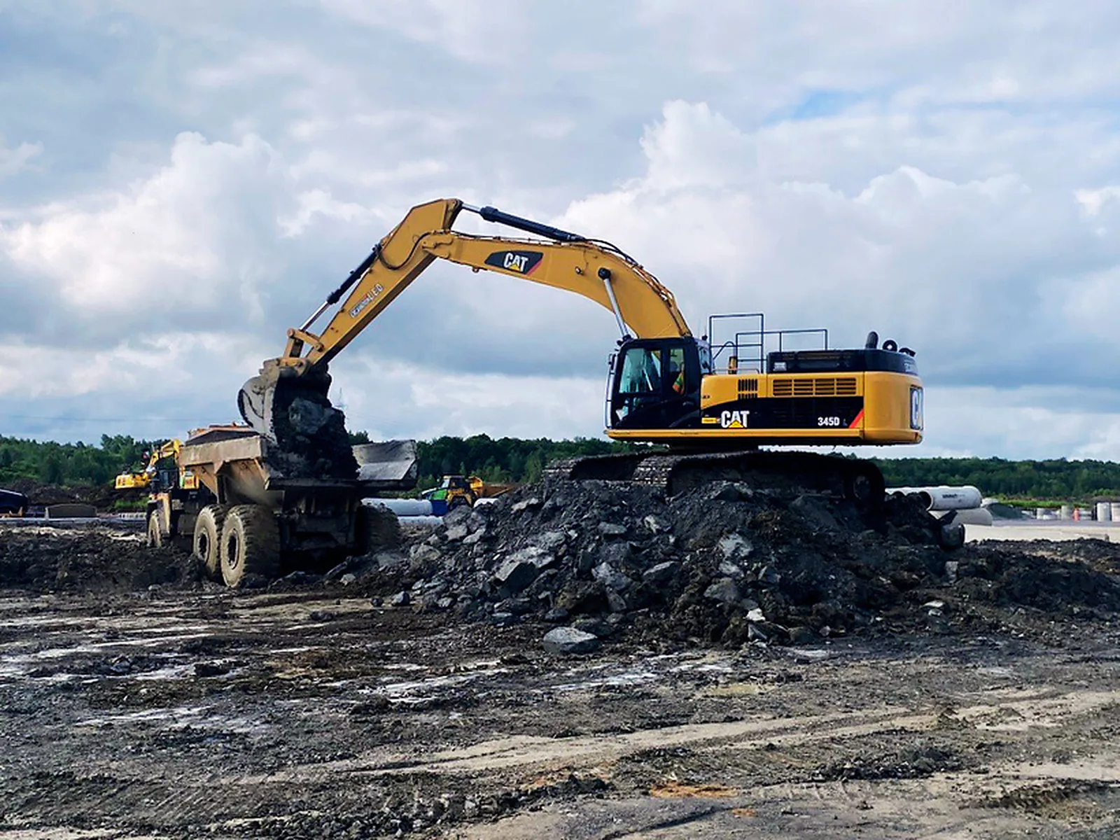 Chargement de tombereau — Pelle Caterpillar chargeant un camion tombereau de sol excavé.