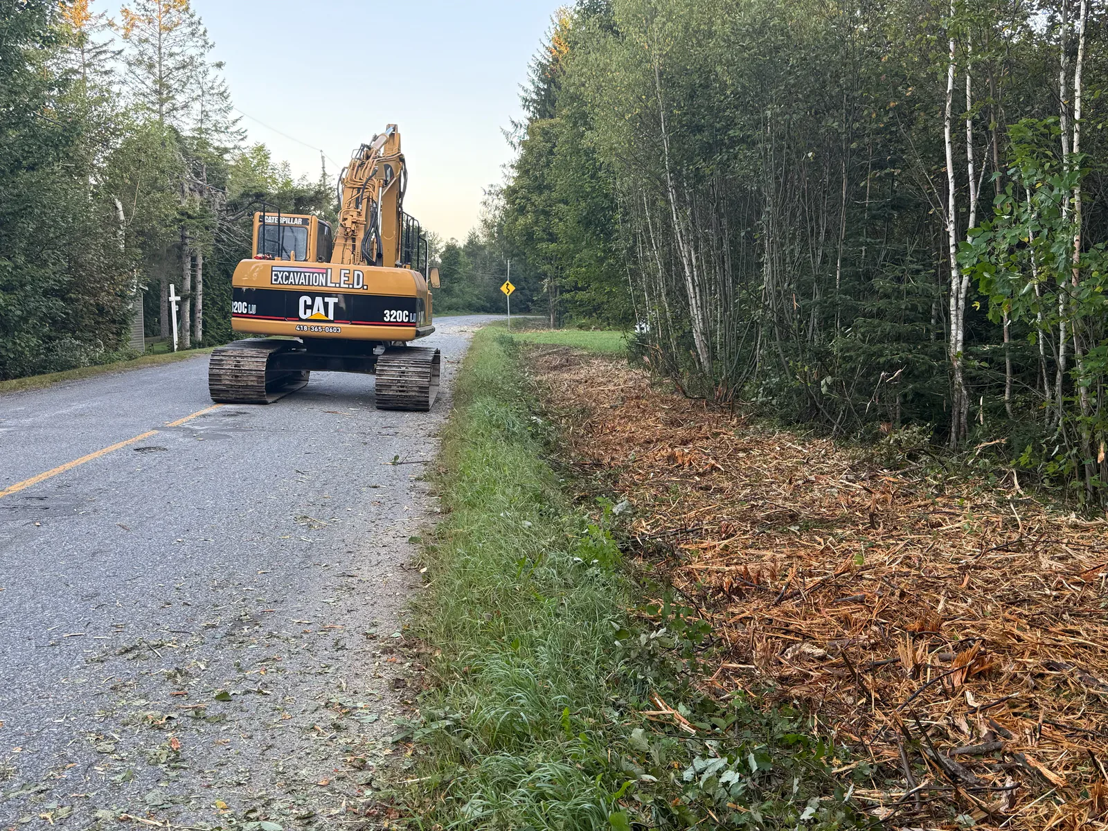 Débroussaillage — Pelle Caterpillar en débroussaillage en bordure de route.